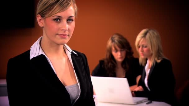 Mujer de negocios rubia con equipo en segundo plano — Vídeos de Stock