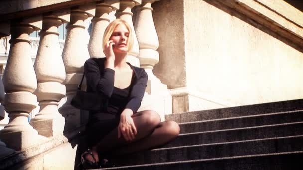 Beautiful blonde in business clothes using mobile phone — Stock Video