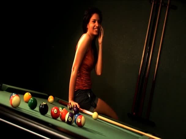 Beautiful latino girl using a cell phone while playing at a pool table — Stock Video