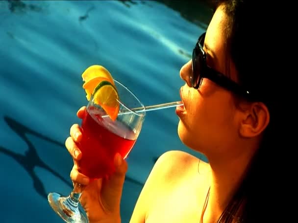 Gros plan d'une belle latino se relaxant avec un cocktail au bord de la piscine — Video