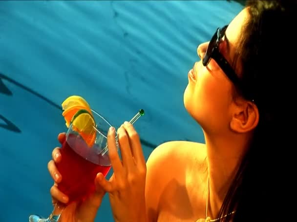 Close-up van mooi latino meisje ontspannen met een cocktail aan het zwembad — Stockvideo
