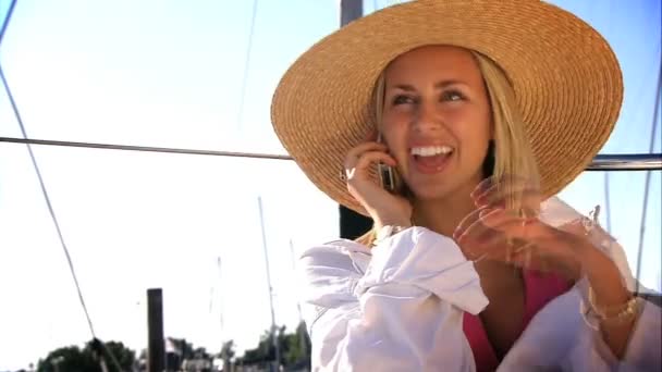 Attractive blonde girl talking on the phone on board her yacht — Stock Video