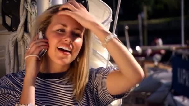 Красивая блондинка по мобильному телефону наслаждается яхтенным стилем жизни — стоковое видео