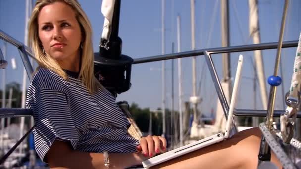 Bella ragazza bionda con il suo computer portatile a bordo di uno yacht di lusso — Video Stock