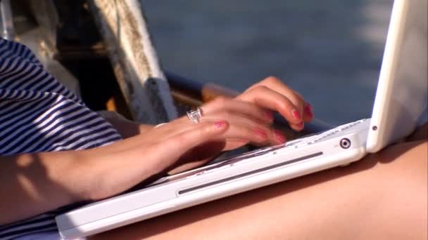 Beautiful blonde girl with her laptop aboard a luxury yacht — Stock Video