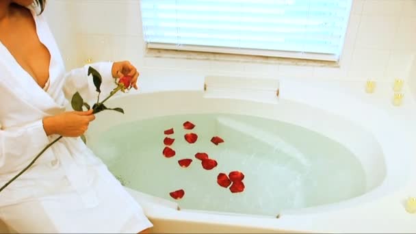 Beautiful latino girl dropping scented petals into bath — Stock Video