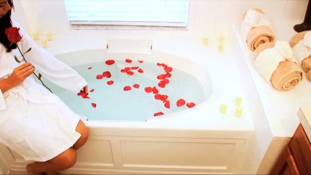 Красивая латиноамериканка бросает ароматные лепестки в ванну — стоковое видео