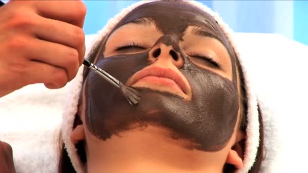 Young brunette girl having facial skin mask — Stock Video