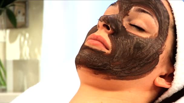 Young brunette girl having facial skin mask — Stock Video