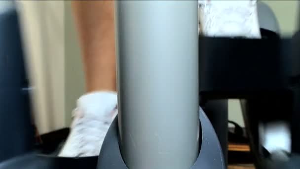 Gros plan jambes & pieds travaillant sur une machine d'exercice dans une salle de gym — Video