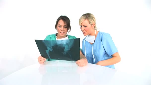 Two young female healthworkers analyzing x-ray exposure — Stock Video