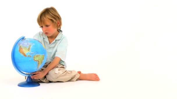 Mały chłopiec kaukaski, patrząc na mapie świata — Wideo stockowe