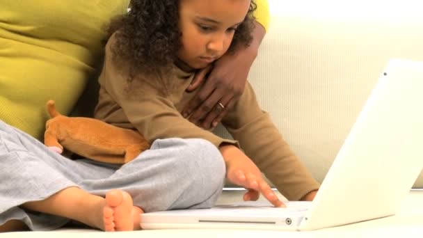 Αφρικανική αμερικανική μητέρα και την χαριτωμένη μικρή κόρη της χρησιμοποιώντας ένα φορητό υπολογιστή — Αρχείο Βίντεο