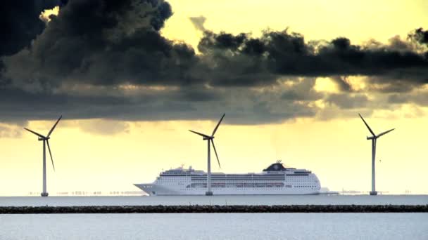 Nave passeggeri di grandi dimensioni che naviga dietro turbine eoliche al largo della costa danese — Video Stock