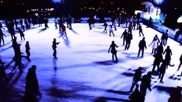 Winter outdoor ice skating with crowds of in silhouette — Stock Video