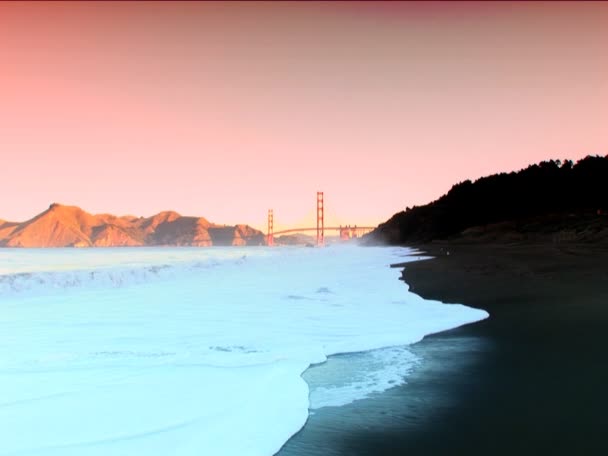 Il Golden Gate Bridge di San Francisco e le onde dell'oceano si infrangono sulla riva — Video Stock