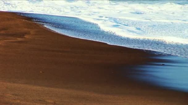 Waves crashing on to a sandy shoreline — Stock Video