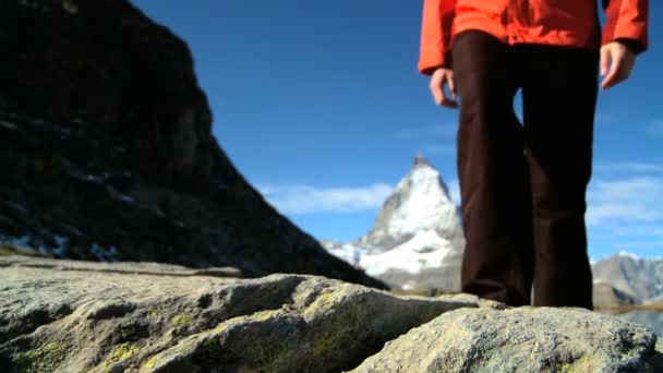 Lone vrouwelijke wandelaar aan de voet van de matterhorn-Zwitserland — Stockvideo