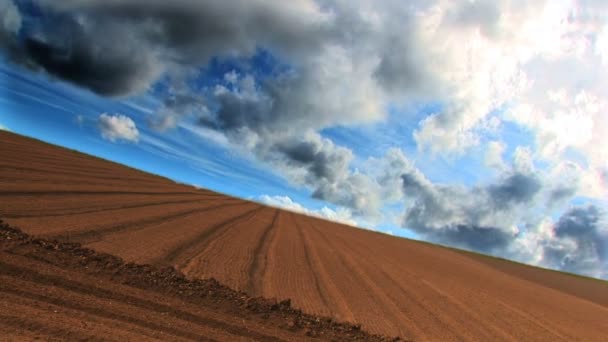 Dramáticas nubes de lapso de tiempo sobre un campo arado — Vídeos de Stock