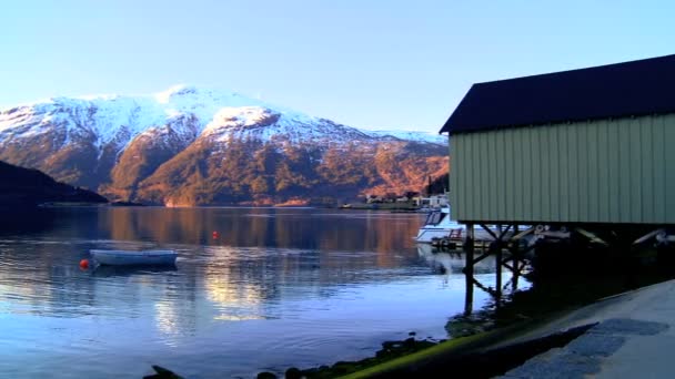 Liten båt flyter på kristallklart vatten i en glacial fjord — Stockvideo