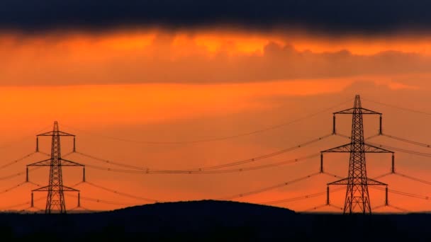 Time-lapse donkere wolken bij zonsondergang over elektriciteit pylonen — Stockvideo