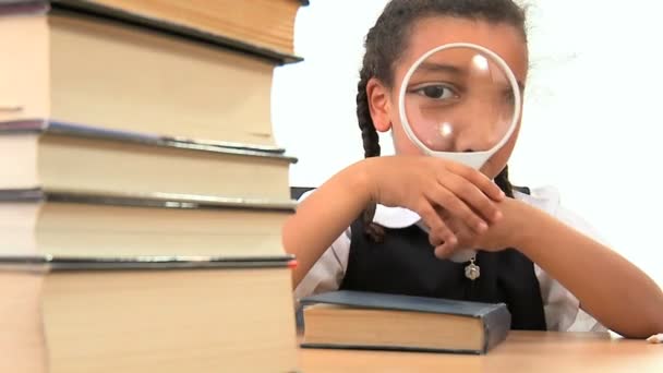 Carino africano americano studentessa utilizzando un vetro spia con un libro — Video Stock