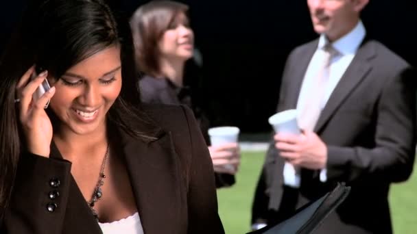 Young city business woman with colleagues talking on mobile(cell)phone — Stock Video