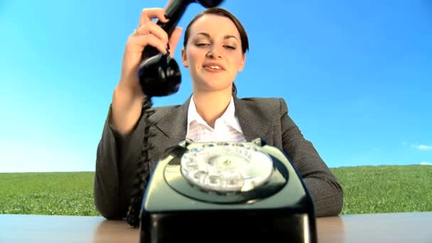 Concept shot of young businesswoman in city clothes using old-fashioned telephone — Stock Video