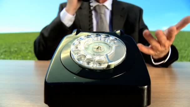 Concept shot of business man in city clothes using old-fashioned telephone in environmental office — Stock Video