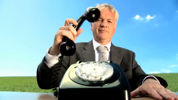 Concept shot of business man in city clothes using old-fashioned telephone in environmental office — Stock Video