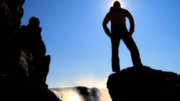 Lone young female reaches a stunning waterfall on her hiking adventure — Stock Video