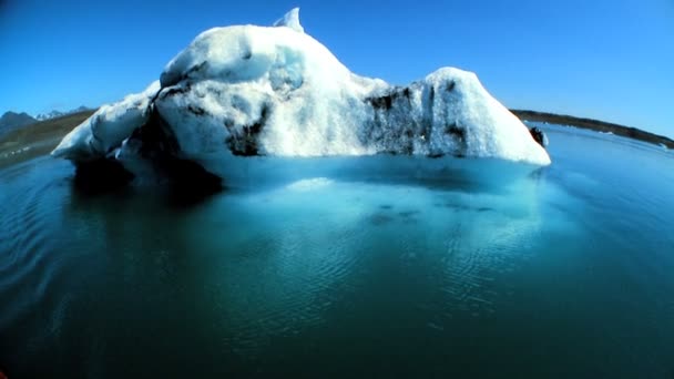 Wide-angle shot of glacial iceberg slowly melting into the lake through global warming — Stock Video