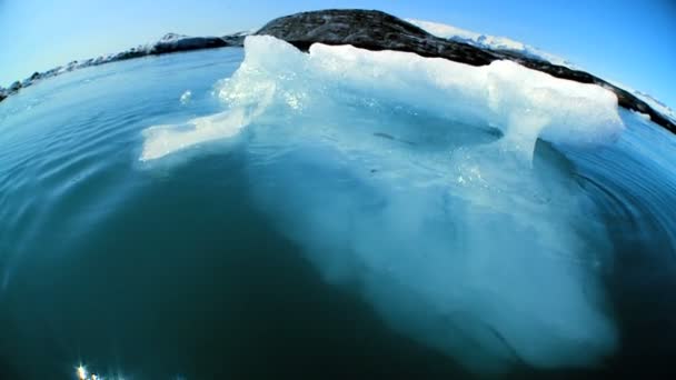 Wide-angle shot of glacial iceberg slowly melting into the lake through global warming — Stock Video