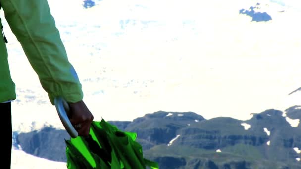 Fotografia conceitual de uma jovem usando guarda-chuva verde para se abrigar das mudanças climáticas — Vídeo de Stock