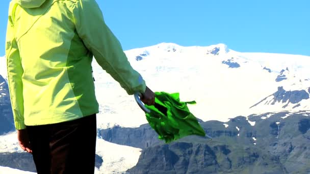 Concept shot of young woman using green umbrella to shelter from climate change — Stock Video