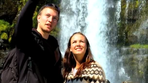 Young couple succeed in their hike to a landmark waterfall — Stock Video