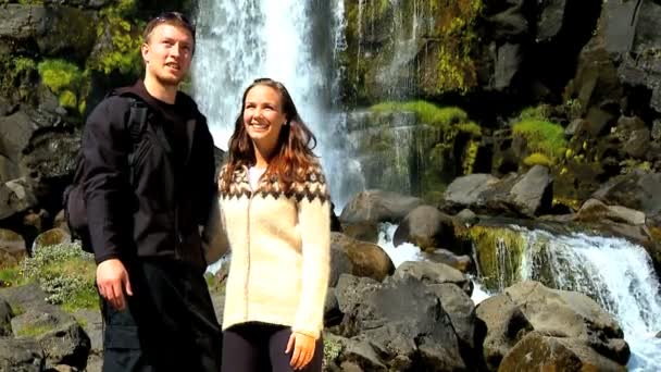 Mladý pár uspět v jejich výlet k vodopádu mezník — Stock video