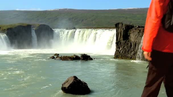 La ecoturista femenina llega a las poderosas aguas de la cascada Godafoss, Islandia — Vídeo de stock