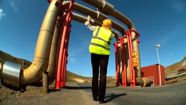 Female geothermal energy technician using a mobile (cell) phone — Stock Video