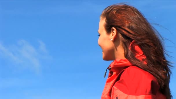 Close-up portrait of beautiful female outdoors against a blue sky background — Stock Video