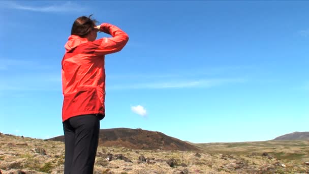 Mujer solitaria caminando por un paisaje islandés estéril — Vídeos de Stock