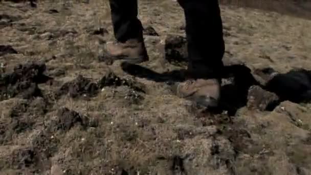 Feet of hiker walking outdoors over rough uneven terrain — Stock Video