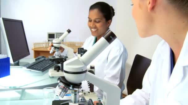 Doctores trabajando en laboratorio con un microscopio — Vídeos de Stock