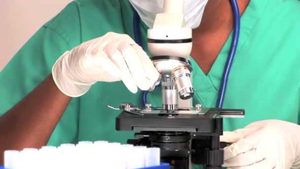 Profissional médico olhando através de um microscópio — Vídeo de Stock