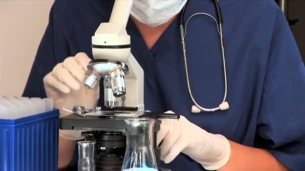 Ιατρικό επαγγελματία που συνεργάζεται με ένα μικροσκόπιο — Αρχείο Βίντεο