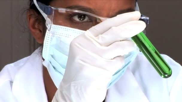 Close-up de cientista feminino examina um tubo de ensaio — Vídeo de Stock