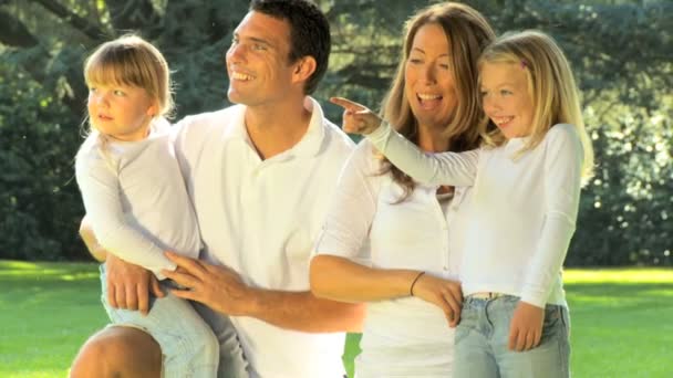 Retrato de una joven familia caucásica disfrutando del tiempo libre juntos en un día de verano — Vídeos de Stock