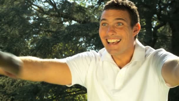 Young father tenderly holding his daughter while outdoors on a summers day — Stock Video