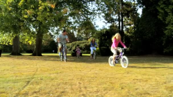 Νεαρή καυκάσιος οικογένεια απολαμβάνοντας την ποδηλασία μαζί για την ημέρα καλοκαίρια — Αρχείο Βίντεο