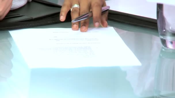 Handen alleen van multi-etnische zakenvrouwen ondertekening van documenten in een moderne kantoor — Stockvideo